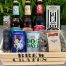 A wooden crate with 2 cans, 3 bottles of beer and some sweet nibblees