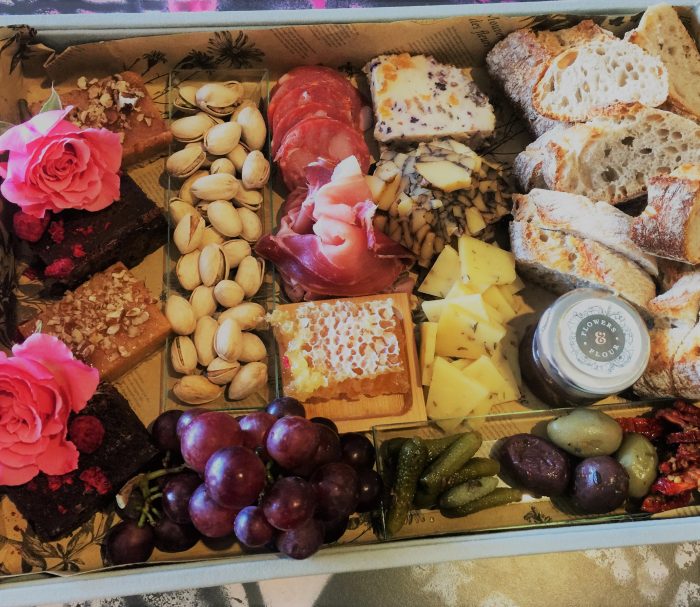 A collection of cold meats, dessert, pickles, fruit and nuts for grazing.